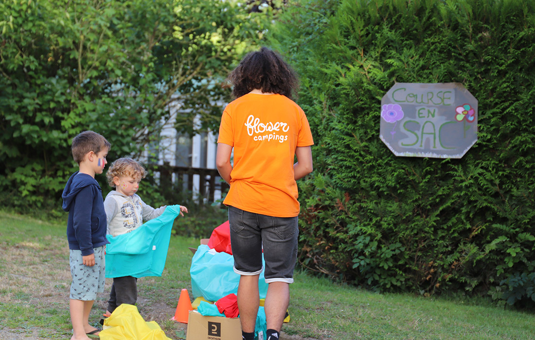Activité course en sac avec des enfants et un animateur